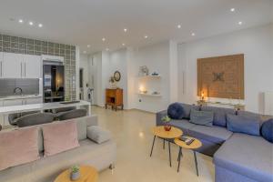 a living room with a blue couch and a kitchen at Kalafatis Downtown Apartment in Itea