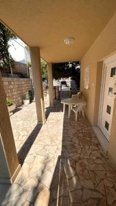a patio with a table and a stone floor at Apartmani Lasić in Podaca
