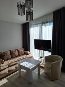 a living room with a couch and a table and a chair at Jurgvita in Palanga