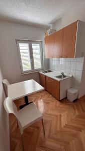 a kitchen with a table and a table and a chair at Apartmani Lasić in Podaca