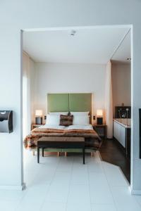 a bedroom with a large bed with a green headboard at Hotel Leidinger - ehemalige Domicil und Domaine Leidinger in Saarbrücken