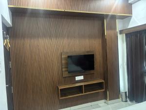 a brown wall with a television on it at Aditya Residency, Bhagalpur in Barāri