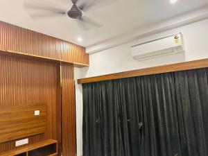 a room with a ceiling fan and a curtain at Aditya Residency, Bhagalpur in Barāri