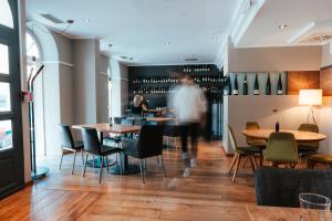 a person walking through a restaurant with tables and chairs at Hotel Leidinger - ehemalige Domicil und Domaine Leidinger in Saarbrücken