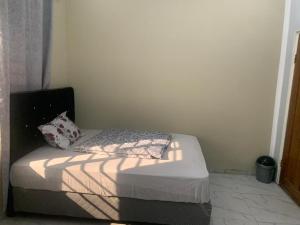 a small bedroom with a bed in the corner at KATEL Green appartements in Kolwezi