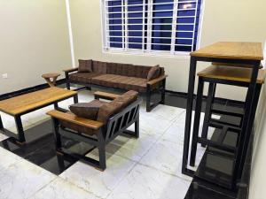 a living room with a couch and tables and a stool at KATEL Green appartements in Kolwezi
