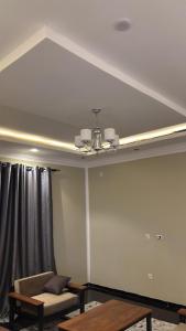 a living room with a ceiling fan and a couch at KATEL Green appartements in Kolwezi +4 photos