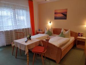 a bedroom with a bed and a table and chairs at Gästehaus Kiesmüller in Aschau im Chiemgau