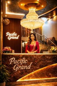 a woman standing behind a counter in a restaurant at Pacific Grand in Amritsar