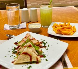 a table with two plates of food and french fries at Hotel SJ in Mosquera +21 photos