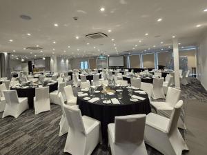 a conference room with tables and white chairs and tablesktop at Mercure Canberra in Canberra +91 photos