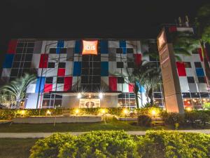a large building with a big sign on it at night at ibis Vitoria Aeroporto in Vitória