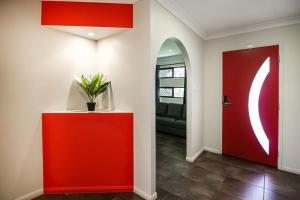 a red door in a living room with a couch at WhitsunStays - Casa Crimson in Mackay