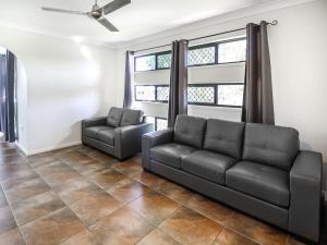 a living room with a couch and a chair at WhitsunStays - Casa Crimson in Mackay