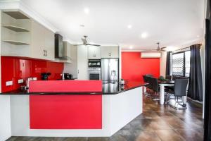 a red and white kitchen with a dining room at WhitsunStays - Casa Crimson in Mackay +18 photos