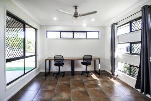 a dining room with a table and two chairs at WhitsunStays - Casa Crimson in Mackay