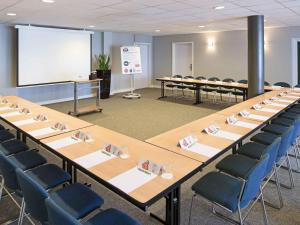 a conference room with tables and chairs and a whiteboard at ibis Luxembourg Sud in Livange