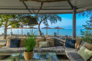 a living room with a couch and a glass table at Kalafatis beach home in Itea