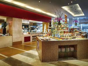 a restaurant with a counter with food on it at Sofitel Xi'an On Renmin Square in Xi'an