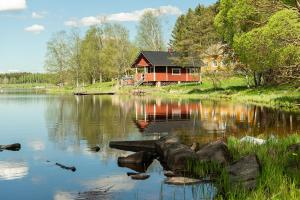 a house sitting on the side of a lake at Taipaleen luomutila in Petäjävesi