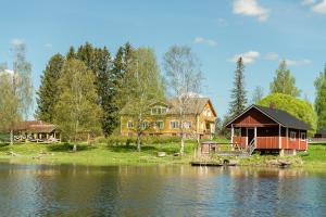 a house on the shore of a body of water at Taipaleen luomutila in Petäjävesi