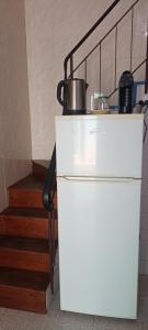a white refrigerator next to a staircase with a pot on it at Casa Fuseta-38 in Fuzeta