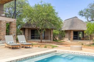 a villa with a pool and a house at Afrikaya Villas in Hoedspruit