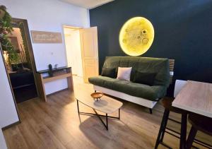a living room with a green couch and a table at L'Evasion Zen au cœur de l'Alsace in Sélestat +10 photos