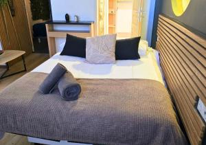 a large bed with pillows on it in a room at L'Evasion Zen au cœur de l'Alsace in Sélestat