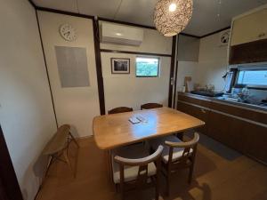 a kitchen with a wooden table and chairs in a room at 古民家宿Step inn Hagi なかつえ in Hagi