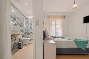 a bedroom with a bed and a bathroom with a tub at Hotel Selini in Agios Nikitas +144 photos