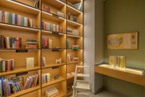 a library with wooden shelves filled with books at Kalafatis beach home in Itea