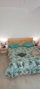a bed with a floral comforter in a bedroom at Casa Fuseta-38 in Fuzeta