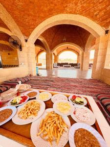 a table with plates of food on it at Nour camp in Nuweiba