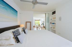 a bedroom with a white bed with a ceiling fan at Beautiful Flat in Mont Choisy in Mont Choisy