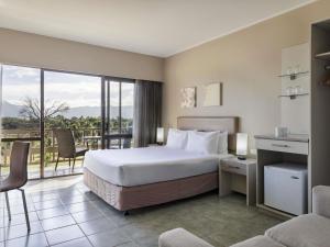 a hotel room with a bed and a balcony at Novotel Nadi in Nadi +54 photos