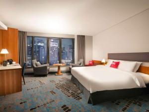 a hotel room with a large bed and a large window at Ibis Ambassador Myeongdong in Seoul +84 photos
