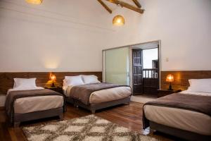 a bedroom with two beds and a mirror at Hotel Casa Fierro Cusco in Cusco