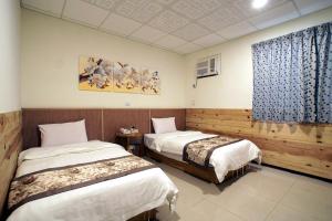 a hotel room with two beds and a window at 楓雅商旅-旅館編號132號 in Taitung City