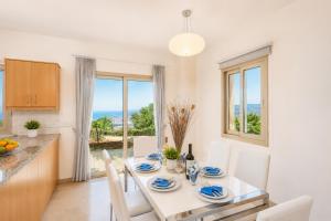 a kitchen and dining room with a table and chairs at Villa Panorama Tessera in Drousha