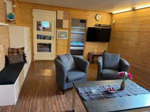 a living room with two chairs and a television at Child friendly basement apartment in Stavanger