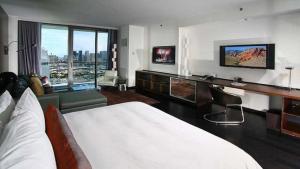 a hotel room with a bed and a desk and a television at Palms Place amazing Strip View 20th floor in Las Vegas