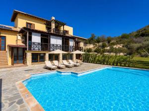 a villa with a swimming pool in front of a house at Villa River View in Peristerona