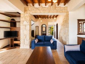a living room with a blue couch and a table at Villa River View in Peristerona