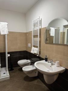 a bathroom with a sink and a toilet and a mirror at Samarè Rooms & Apartments in Bisceglie +30 photos
