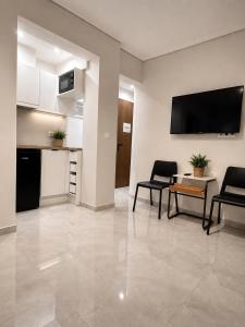 a living room with a table and chairs and a tv at Xsoma Flats "Studio" in Thessaloniki
