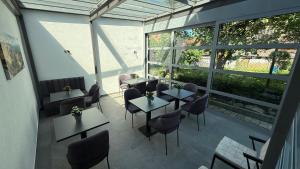 a restaurant with tables and chairs and large windows at Hotel am Kocher in Schwäbisch Hall