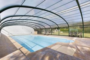 an indoor swimming pool with a glass roof at La Ferme Des Bigornes in Châtillon-sur-Indre