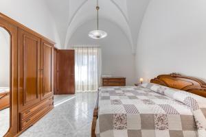 ein Schlafzimmer mit einem Bett und einem Holzschrank in der Unterkunft Da lu Pira in Patù
