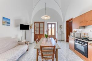 eine Küche und ein Wohnzimmer mit einem Tisch und einem Sofa in der Unterkunft Da lu Pira in Patù